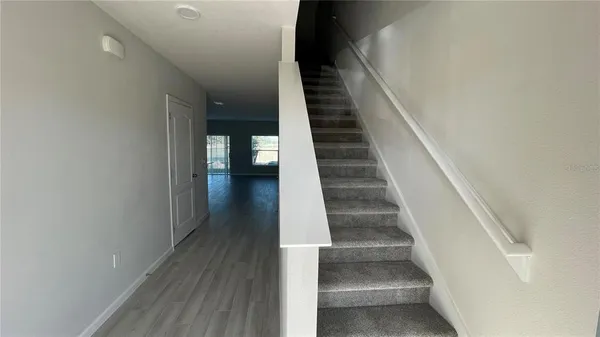 a view of entryway and hall with wooden floor