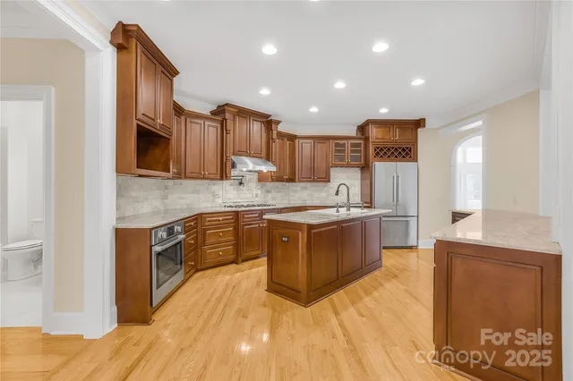 a large kitchen with stainless steel appliances granite countertop a stove a sink dishwasher and a microwave oven with white cabinets