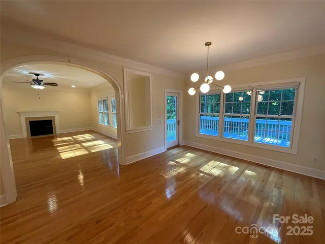 a view of a livingroom with wooden floor and a fireplace