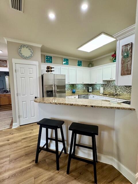 136 Shorebird Drive, Unit 724 Santa Rosa Beach, FL 32459 - Photo 15 of 49 a kitchen with stainless steel appliances granite countertop a table chairs sink and cabinets