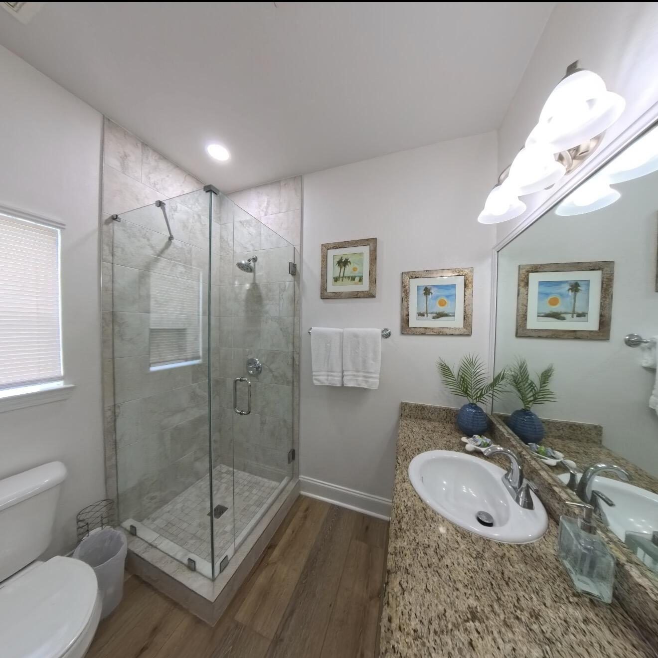 136 Shorebird Drive, Unit 724 Santa Rosa Beach, FL 32459 - Photo 22 of 49 a bathroom with a granite countertop sink a mirror a toilet and shower