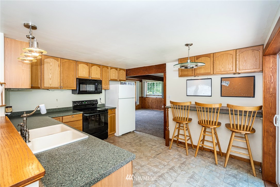 1561 King Road Winlock, WA 98596 - Photo 14 of 23 a kitchen with stainless steel appliances granite countertop a stove top oven a sink a dining table and chairs