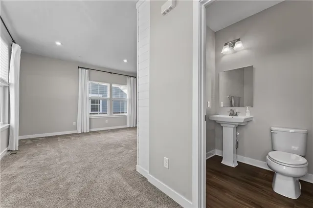 a bathroom with a toilet sink a shower and a window