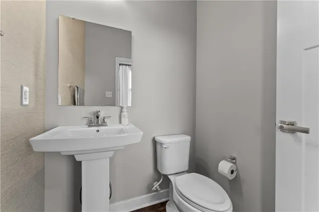 a bathroom with a toilet sink and mirror