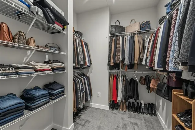 a view of walk in closet with clothes and shoes