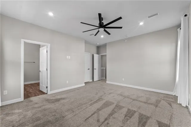 an empty room with closet and a ceiling fan