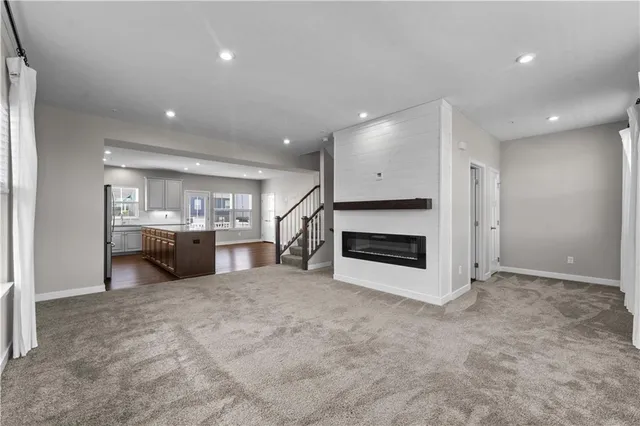 a view of a kitchen with a sink a fireplace and a refrigerator