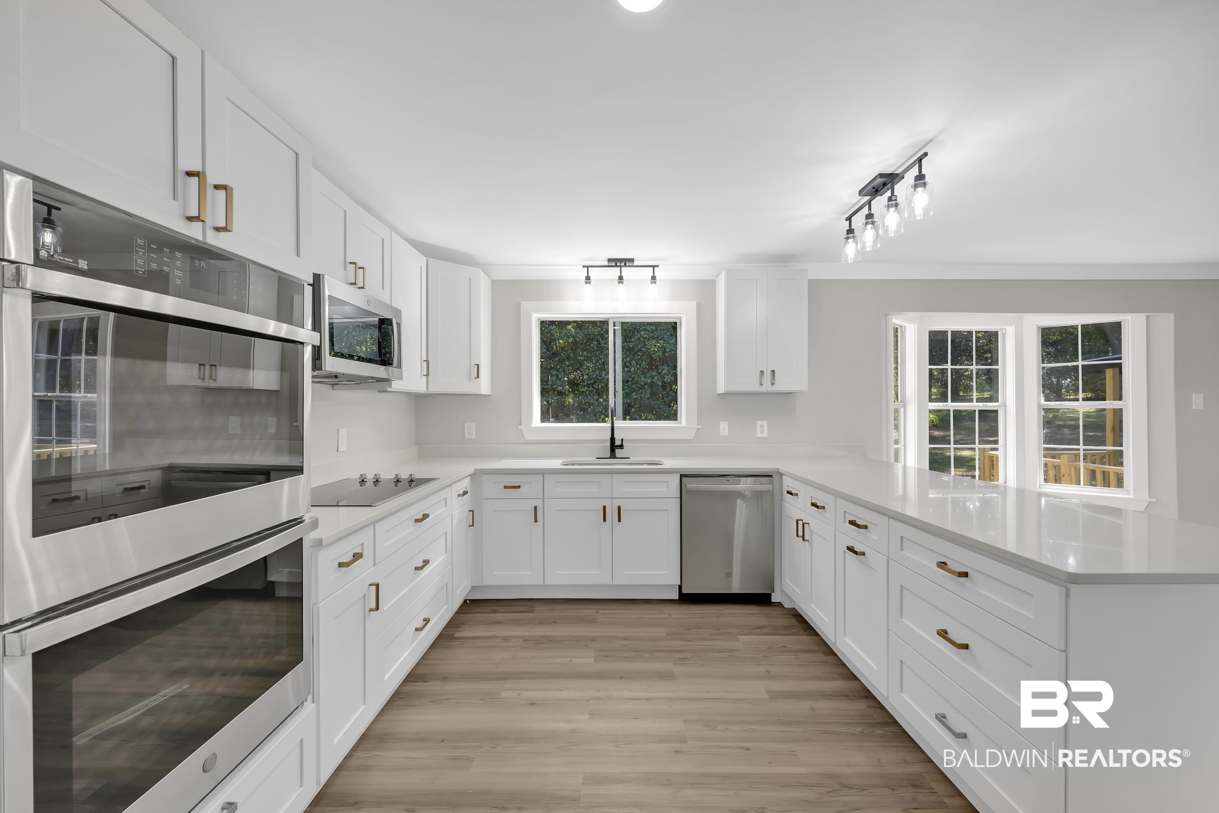 8351 Theodore Dawes Road Theodore, AL 36582 - Photo 13 of 46 Kitchen with appliances with stainless steel finishes, white cabinetry, healthy amount of natural light, and a peninsula