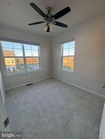 an empty room with a window and a ceiling fan