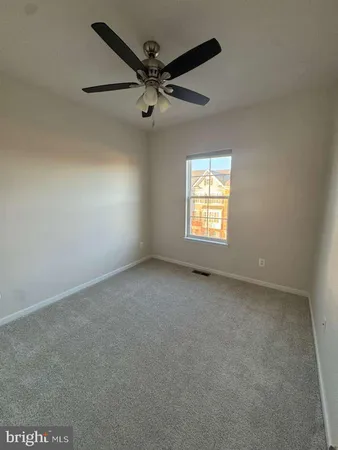 an empty room with a window and a fan
