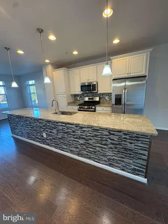 a kitchen with kitchen island counter top space a sink and appliances