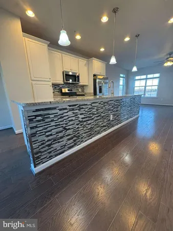 a view of kitchen with stainless steel appliances granite countertop a stove a sink and a microwave