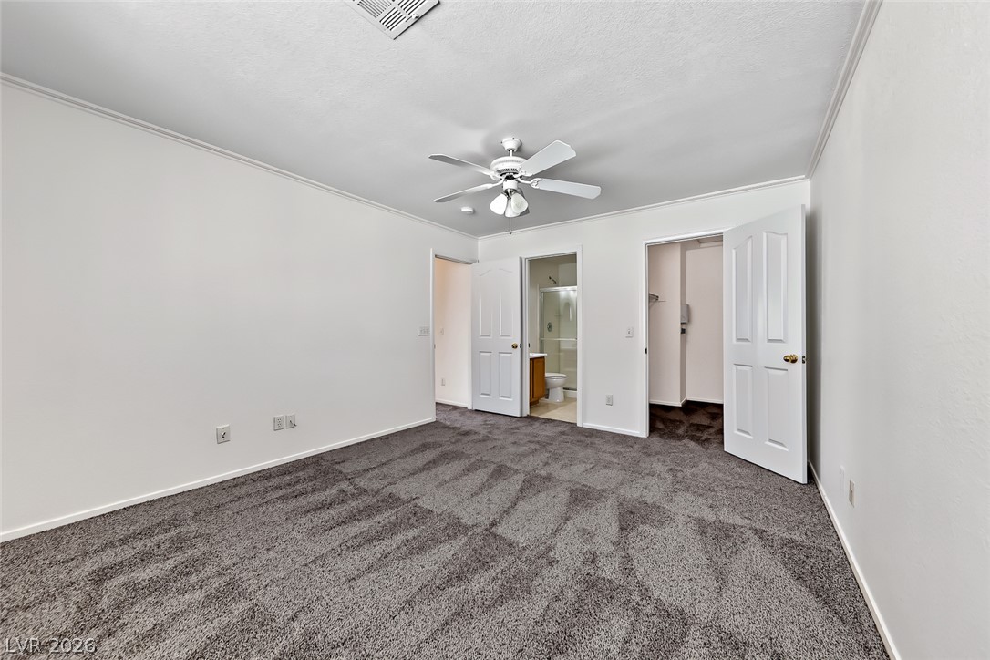205 Genesee Point Street Henderson, NV 89074 - Photo 16 of 30 Plush wall-to-wall carpeting and clean crown molding define this versatile secondary bedroom space.