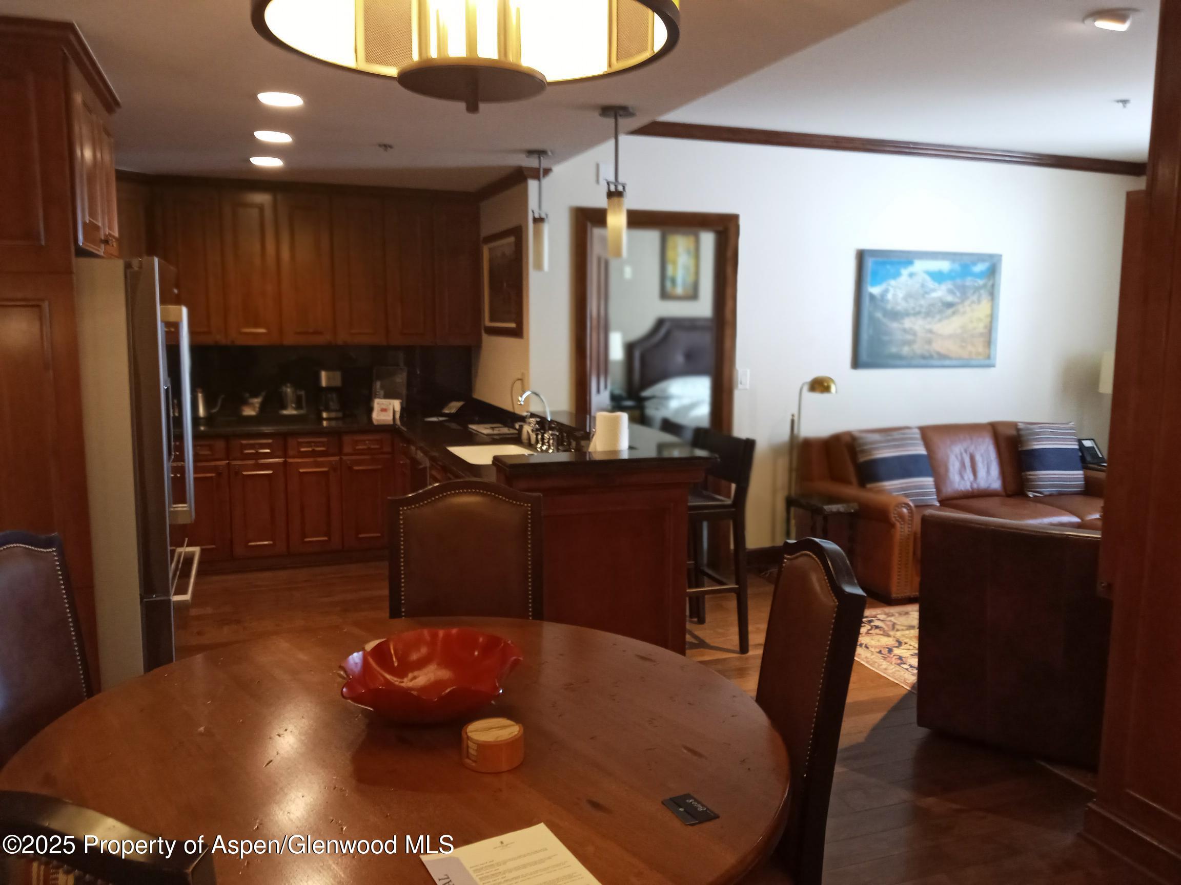 75 Prospector Road, Unit 8408 WINTER INTEREST #6 Aspen, CO 81611 - Photo 23 of 32 a dining room with furniture and wooden floor