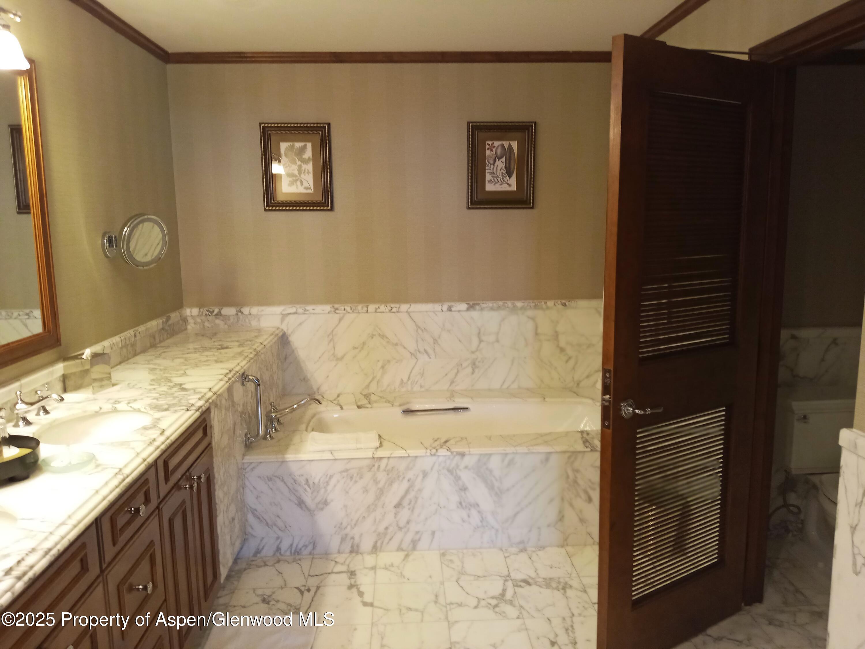 75 Prospector Road, Unit 8408 WINTER INTEREST #6 Aspen, CO 81611 - Photo 24 of 32 a bathroom with a granite countertop sink a mirror and a bathtub