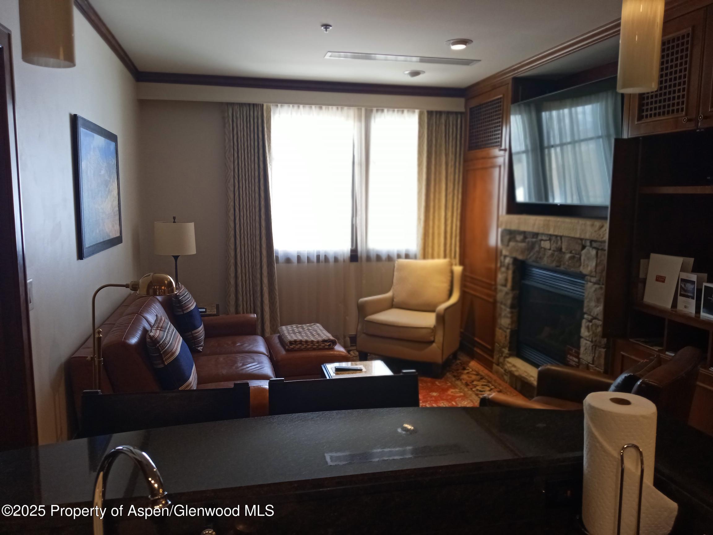 75 Prospector Road, Unit 8408 WINTER INTEREST #6 Aspen, CO 81611 - Photo 27 of 32 a living room with furniture fireplace and a flat screen tv