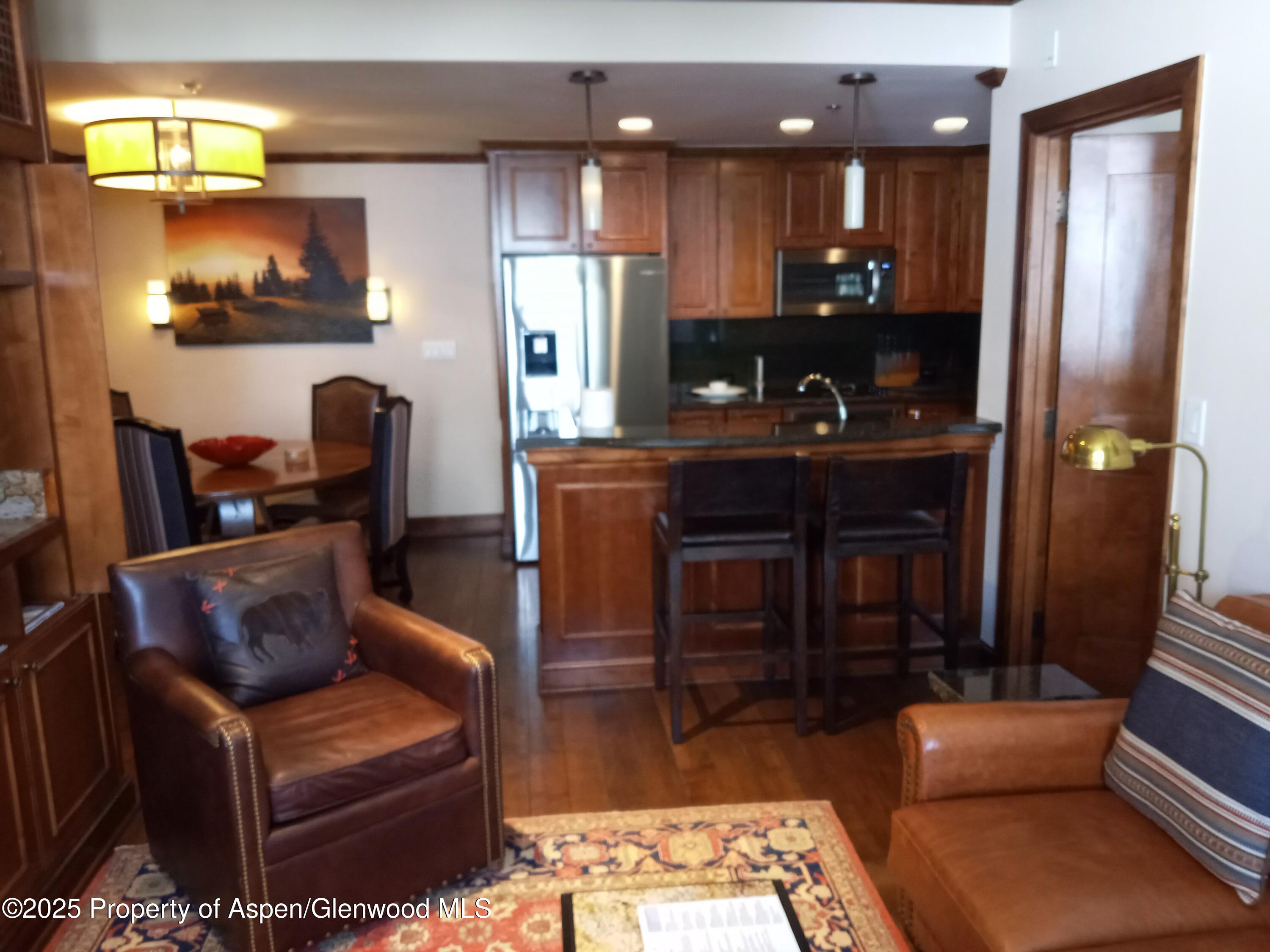 75 Prospector Road, Unit 8408 WINTER INTEREST #6 Aspen, CO 81611 - Photo 31 of 32 a living room with stainless steel appliances furniture a rug and a view of kitchen