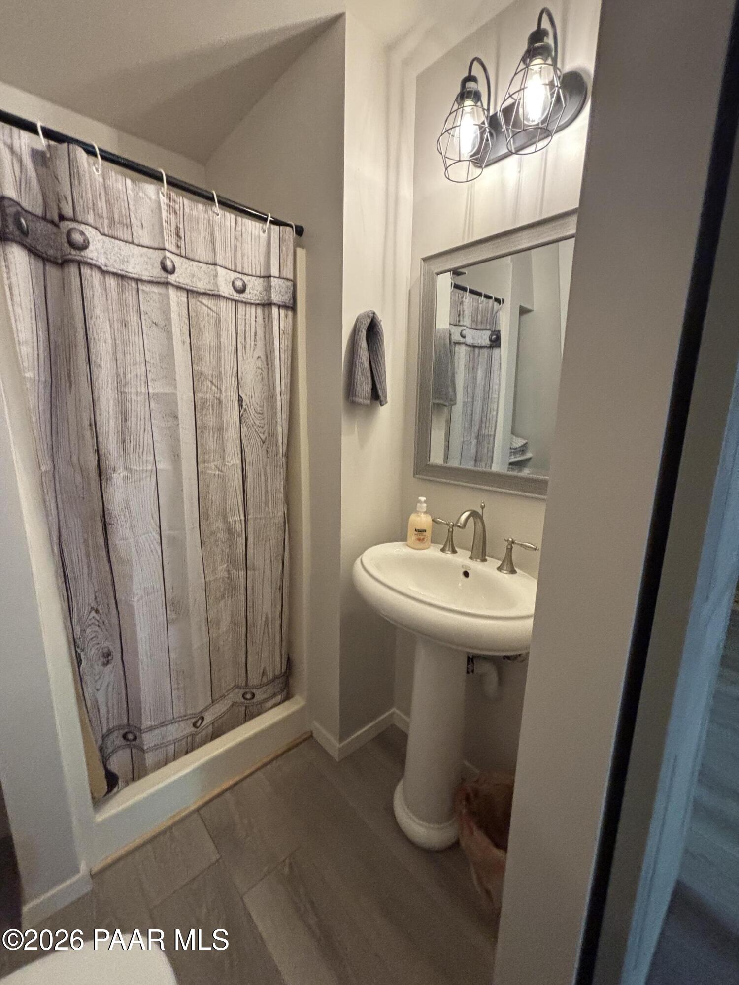 8550 South Breezy Pine Road Mayer, AZ 86333 - Photo 31 of 40 a bathroom with a sink a mirror and a toilet
