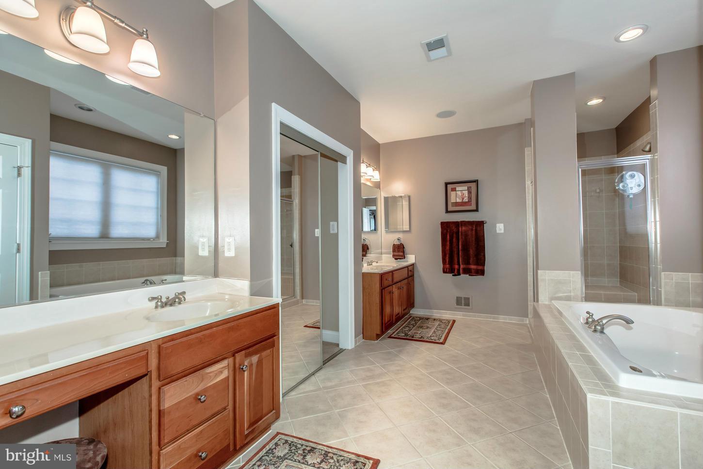 1152 Markell Court Reston, VA 20194 - Photo 16 of 30 a spacious bathroom with a shower tub double sink and mirror