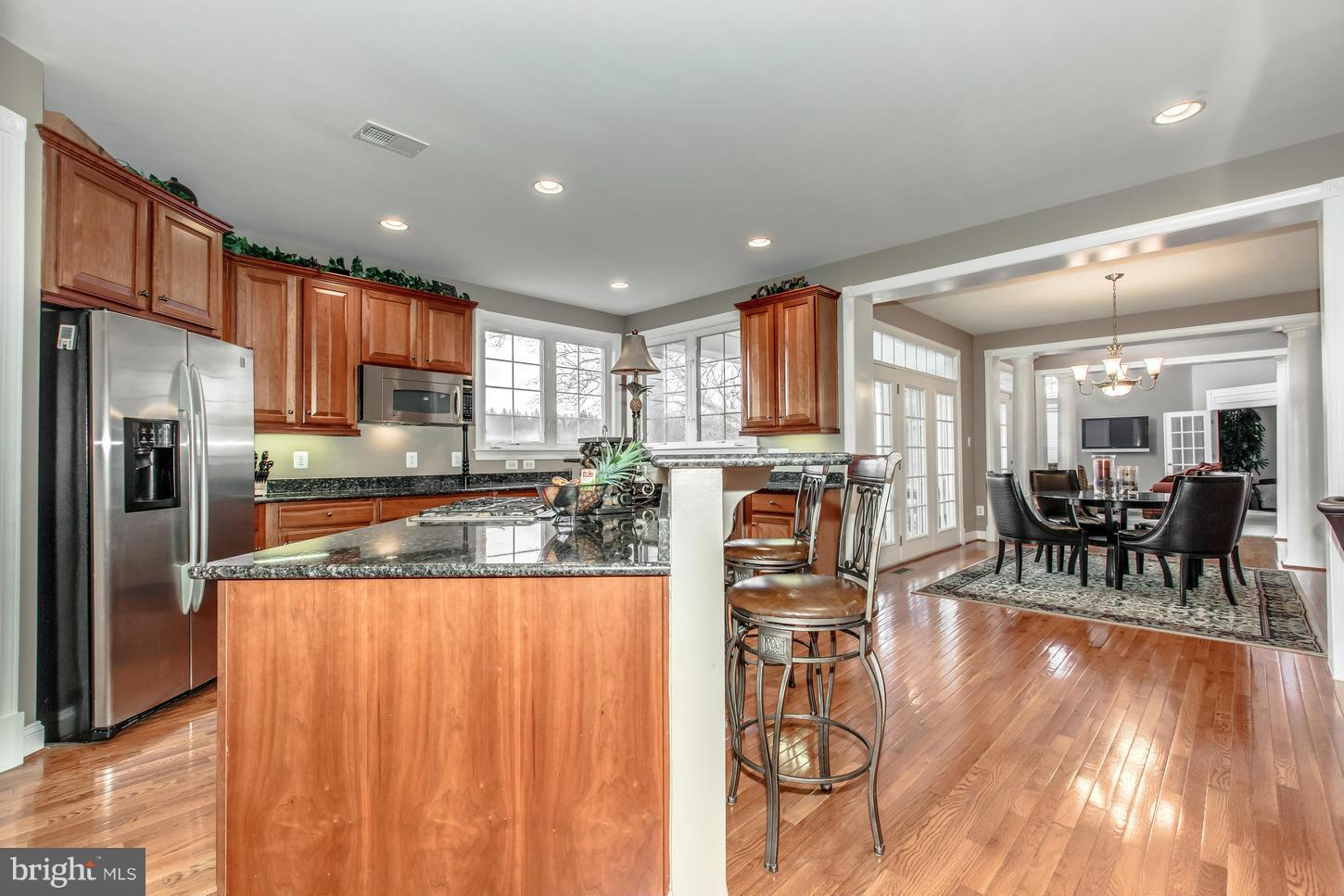 1152 Markell Court Reston, VA 20194 - Photo 9 of 30 a kitchen with stainless steel appliances granite countertop a refrigerator a stove a sink a dining table and chairs with wooden floor