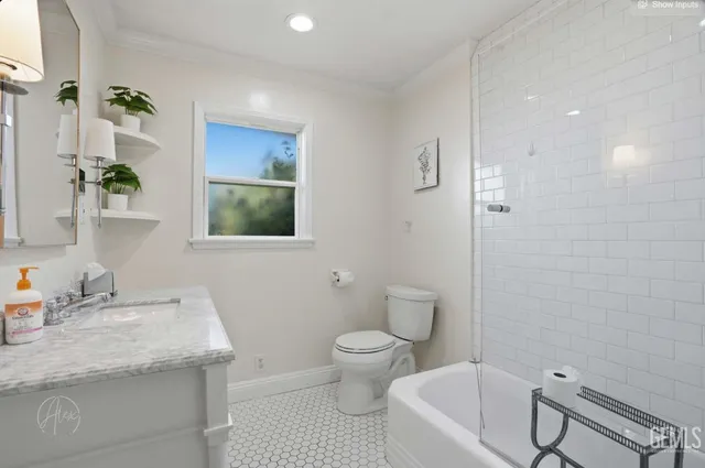 a bathroom with a granite countertop sink a toilet a mirror and shower