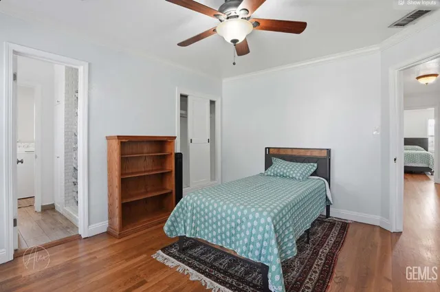 a bedroom with a bed and wooden floor