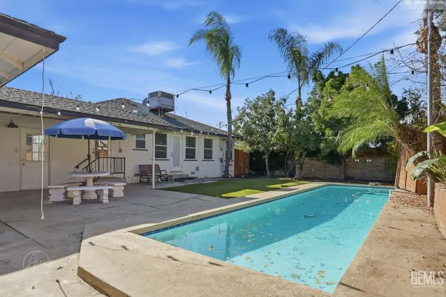 a view of a house with swimming pool and sitting area