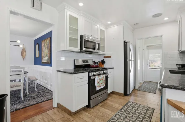 a kitchen with stainless steel appliances granite countertop a refrigerator stove microwave and sink