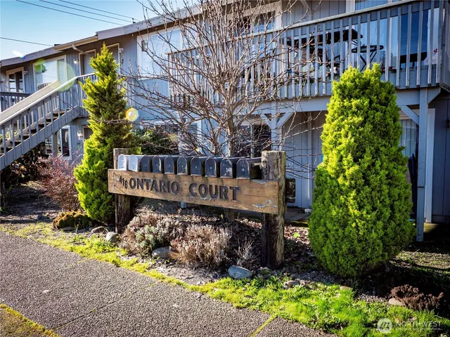 a view of a house with a yard and potted plants