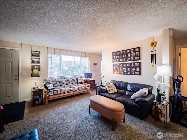 a living room with furniture a rug and a large window