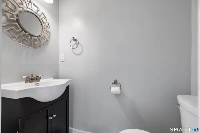 a bathroom with a sink mirror vanity and toilet