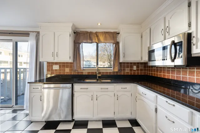 a kitchen with stainless steel appliances a sink a stove a microwave and cabinets