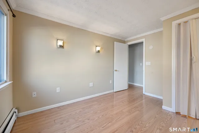 a view of an empty room with wooden floor