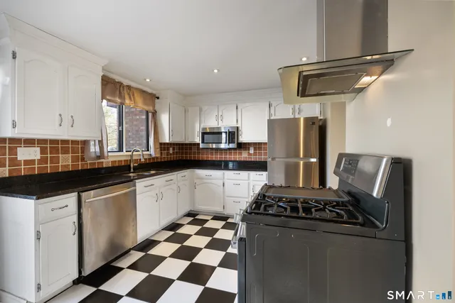 a kitchen with stainless steel appliances granite countertop a sink stove and refrigerator