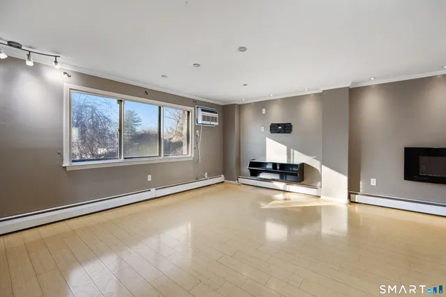 a view of empty room with a fireplace and wooden floor