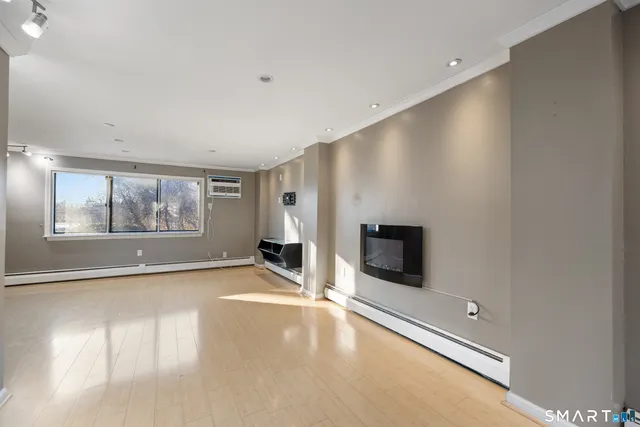 an empty room with windows and fireplace