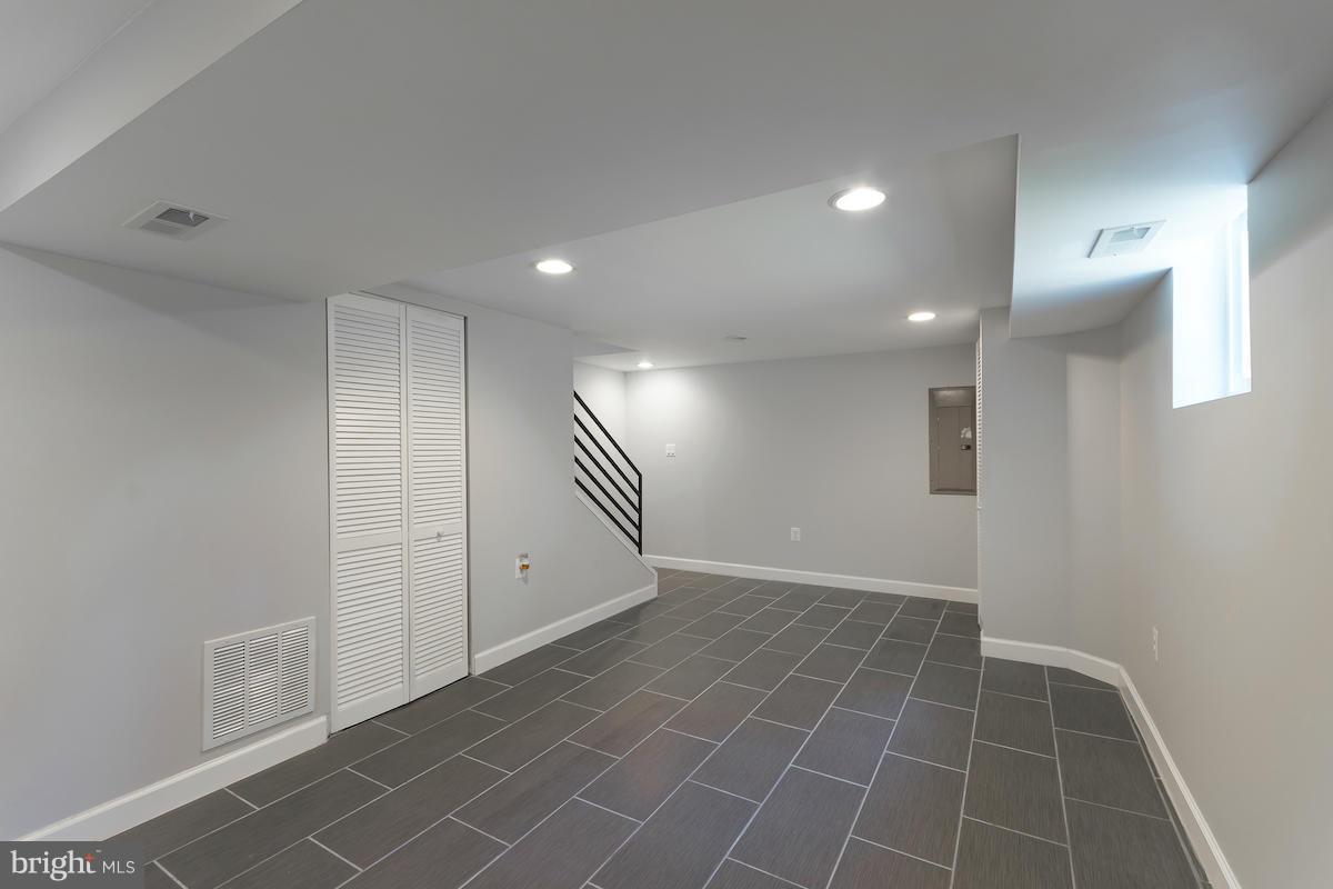 5093 Sheriff Road Northeast Washington, DC 20019 - Photo 13 of 14 an empty room with white walls and tiles
