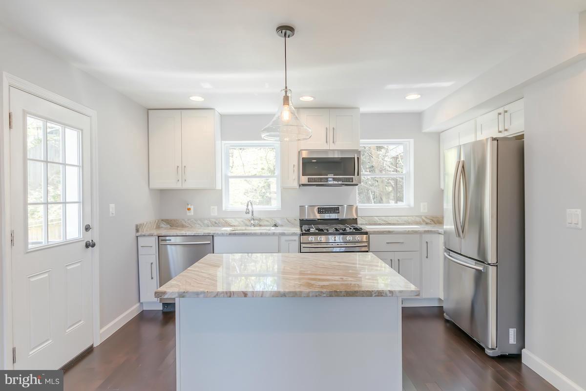 5093 Sheriff Road Northeast Washington, DC 20019 - Photo 4 of 14 a kitchen with kitchen island granite countertop appliances cabinets a sink and a center island