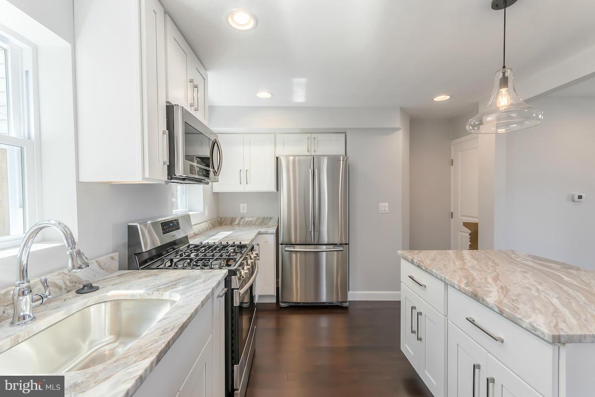 5093 Sheriff Road Northeast Washington, DC 20019 - Photo 6 of 14 a kitchen with a sink stove and refrigerator