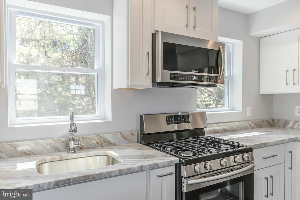 5093 Sheriff Road Northeast Washington, DC 20019 - Photo 7 of 14 a kitchen with granite countertop a sink and a stove top oven
