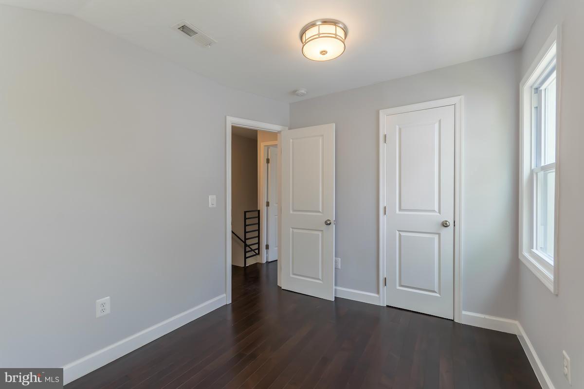 5093 Sheriff Road Northeast Washington, DC 20019 - Photo 9 of 14 an empty room with wooden floor and windows