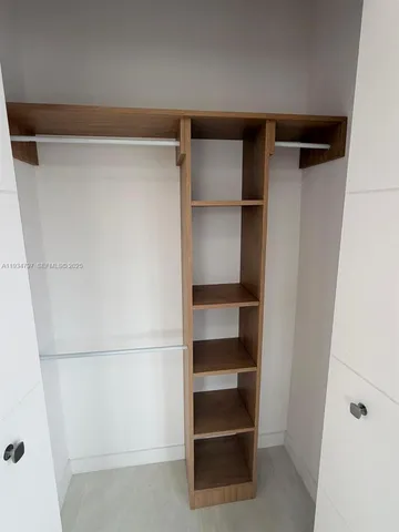 a view of walk in closet with empty racks