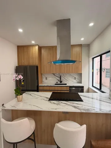 a kitchen with kitchen island granite countertop a sink and a stove