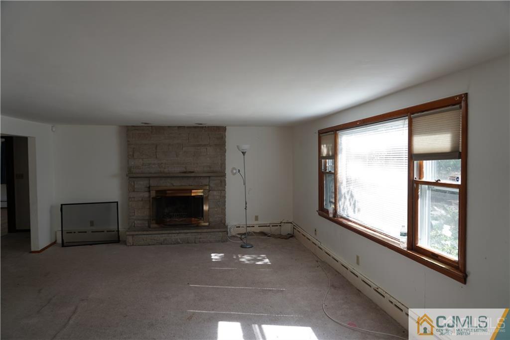 634 Old Stage Road East Brunswick, NJ 08816 - Photo 16 of 17 an empty room with windows and fireplace