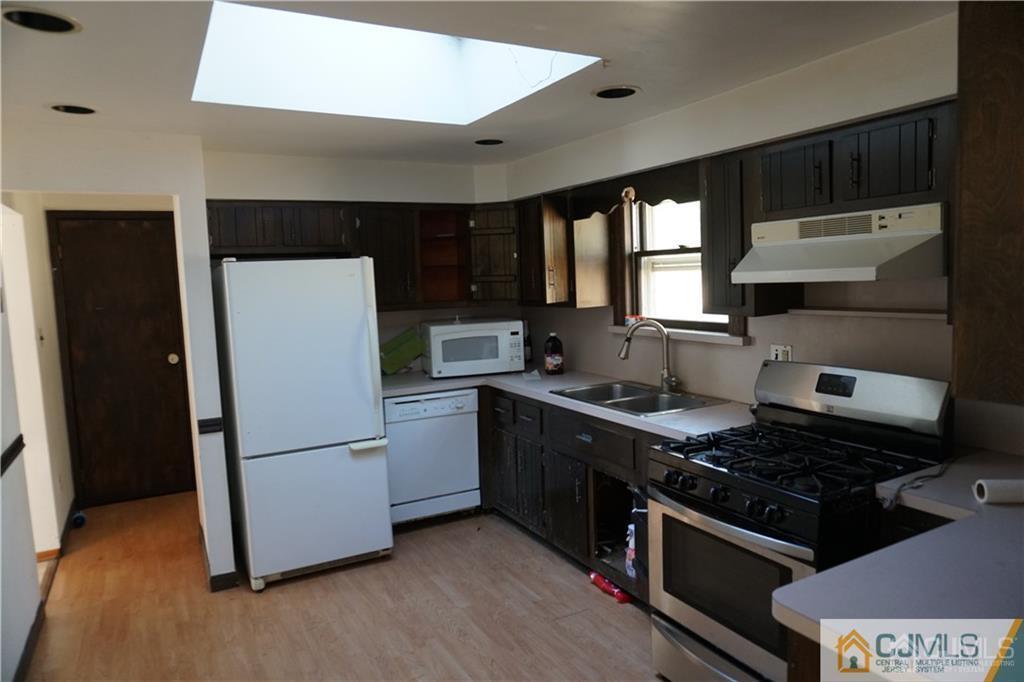 634 Old Stage Road East Brunswick, NJ 08816 - Photo 2 of 17 a kitchen with a refrigerator and a stove