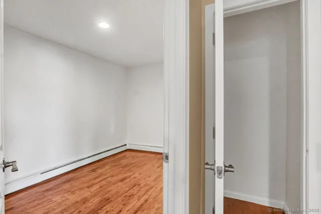 a view of empty room with wooden floor