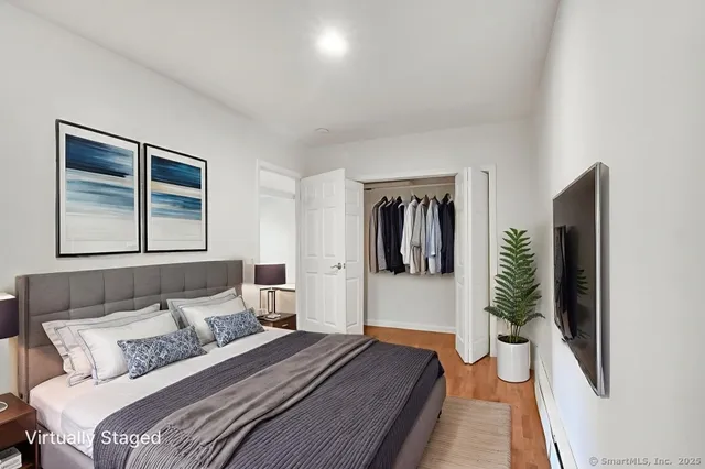 a bedroom with a bed and a large mirror next to a window