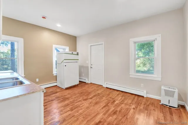 a view of a livingroom with a computer on the desk and a window