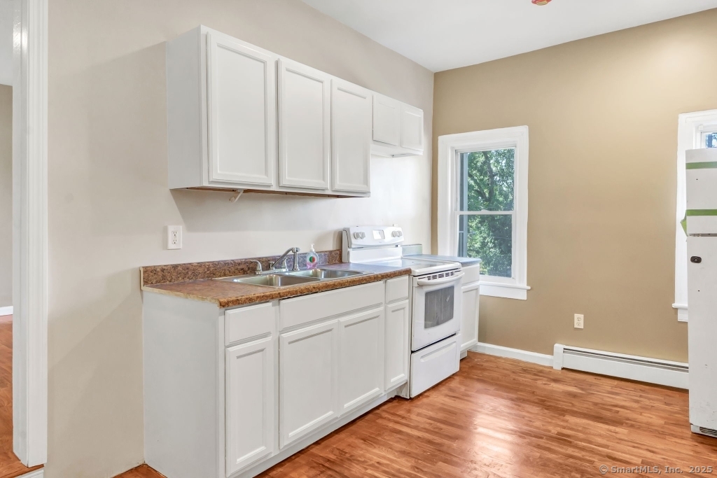 100 Mt Pleasant Street Derby, CT 06418 - Photo 25 of 40 a kitchen with granite countertop white cabinets and white appliances