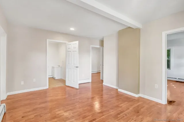 a view of empty room with wooden floor